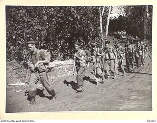BOUGAINVILLE, 1945-07-13. TROOPS OF 29 INFANTRY BRIGADE MOVING THROUGH A MUDDY SECTION OF THE BUIN ROAD BETWEEN THE OGORATA RIVER AND THE MOBIAI RIVER. OWING TO HEAVY RAINS THE ROAD HAS BEEN ..