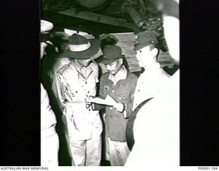 THE SOLOMON ISLANDS, 1945-08-20. ALLIED AND JAPANESE SERVICE PERSONNEL ON BOARD HMAS LITHGOW OFF MOILA POINT STUDY A DOCUMENT RELATING TO A PROPOSED SURRENDER CEREMONY AT TOROKINA. (RNZAF OFFICIAL ..