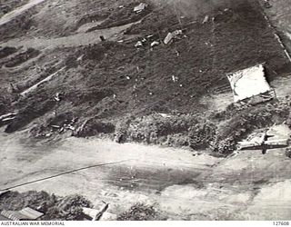 VUNAKANOU, NEW GUINEA. 1943-10-24. VIEW FROM FIFTH AIR FORCE, UNITED STATES ARMY AIR FORCE BOMBER APPROACHING THE AIRSTRIP, WITH FIGHTER AIRCRAFT, 'JAKES' AND 'ZEROS', IN REVETMENTS. NEAR THE HUTS ..