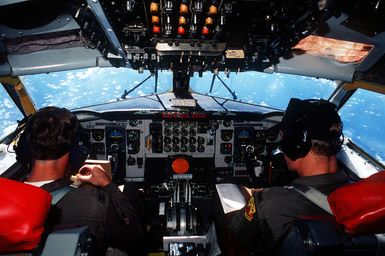 CAPT. James Herrin, pilot, and LT. Jason Walls, co-pilot, eat lunch aboard their KC-135A Stratotanker aircraft enroute to Anderson Air Force Base, Guam. The plane will later continue on to Saudi Arabia to take part in Operation Desert Shield. Both Herrin and Walls are members of the 924th Air Refueling Squadron