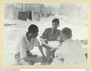 TOROKINA, BOUGAINVILLE ISLAND, 1945-01-05. SERGEANT H. HONG CHOY, LANGUAGE DETACHMENT LAND HEADQUARTERS, HEADQUARTERS, 2ND AUSTRALIAN CORPS QUESTIONING A CHINESE WHO HAD BEEN CONSCRIPTED INTO THE ..