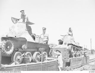 1942-10-19. AUSTRALIAN OFFICERS INSPECT TWO JAPANESE TYPE 95 HA-GO LIGHT TANKS THAT WERE KNOCKED OUT BY AUSTRALIAN TROOPS IN THE ATTEMPTED JAPANESE INVASION AT MILNE BAY. (NEGATIVE BY ANDERSON)