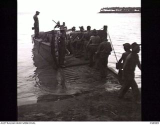 FINSCHHAFEN AREA, NEW GUINEA. 1943-10-27. TROOPS OF THE 2/3RD AUSTRALIAN PIONEER BATTALION LOADING STORES ONTO BARGES AT KEDAM BEACH FOR TRANSHIPMENT TO LAUNCH JETTY
