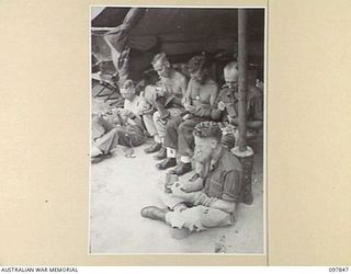 CAPE WOM, WEWAK AREA, NEW GUINEA. 1945-10-13. MEMBERS OF C COMPANY, 2/1 GUARD REGIMENT, DOING THEIR MENDING. IDENTIFIED PERSONNEL ARE:- PRIVATE R. RAE (1); PRIVATE T.F. BURGESS (2); PRIVATE M.W. ..