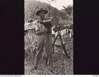 KAIAPIT, NEW GUINEA. 1943-09-24. VX27806 LIEUTENANT J. M. SANDELL, STATION COMMAND OFFICER, 7TH AUSTRALIAN DIVISION OPERATING AN ALDIS LAMP, AT THE AIRSTRIP