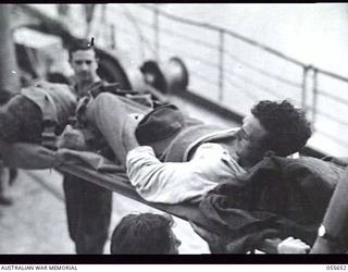 NEW GUINEA. 1943-07-28. AUSTRALIAN WOUNDED FROM NASSAU BAY BEING TAKEN OFF THE TUNGSIN. STRETCHER BEARER IS:- PRIVATE H. CLANINGBOLD, 10TH AUSTRALIAN FIELD AMBULANCE (1)