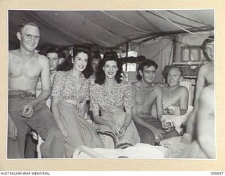 TOROKINA, BOUGAINVILLE. 1945-04-16. DOLLY MAC (1), AND ELVA QUIN (2), MEMBERS OF THE BOB DYER CONCERT PARTY, TALKING TO PATIENTS AT THE 2/1 GENERAL HOSPITAL