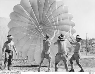 3 MILE, PORT MORESBY, NEW GUINEA. 1943-12-14. PERSONNEL OF THE 1ST AUSTRALIAN PARACHUTE REFOLDING PLATOON, AUSTRALIAN ARMY ORDNANCE CORPS, CHECKING AN AMERICAN 24 FOOT CARGO DROPPING PARACHUTE. ..