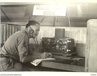 PORT MORESBY, PAPUA, 1944-02-26. N245943 SIGNALMAN K.P. STINSON (1) AT A NO.4 WIRELESS RECEIVER AT THE NEW GUINEA FORCE SIGNAL OFFICE WHICH IS MANNED BY PERSONNEL OF THE 18TH LINES OF COMMUNICATION ..