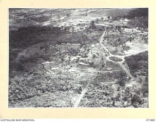 LAE, NEW GUINEA. 1944-03-30. AN AERIAL VIEW OF THE HEADQUARTERS LAE BASE SUB AREA (FOREGROUND), WITH CHARING CROSS (RIGHT BACKGROUND), AND THE BUTIBUM RIVER FLOWING IN THE EXTREME BACKGROUND