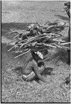 Child carries large bundle of firewood and garden produce on head