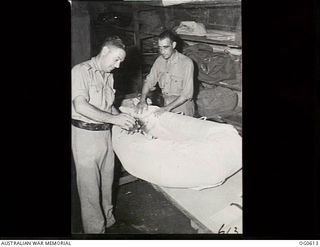 VIVIGANI, GOODENOUGH ISLAND, PAPUA. C. 1943-10. IN THE PARACHUTE SECTION, NO. 30 BEAUFIGHTER SQUADRON RAAF, LEADING AIRCRAFTMAN (LAC) H. MARKS, BONDI, NSW (LEFT) AND LAC A. N. BELCHER, BLACKWOOD, ..