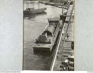 MILNE BAY, NEW GUINEA. 1944-04-05. A LANDING CRAFT MECHANIZED FITTED WITH A 5,000 GALLON TANK TO SUPPLY SMALL CRAFT WITH DISTILLATE, AND MOORED TO THE OIL WHARF OF THE 2ND AUSTRALIAN BULK PETROLEUM ..