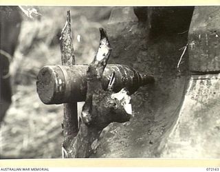 FORTIFICATION POINT, NEW GUINEA. 1944-04-06. A ROUND OF 75MM AMMUNITION READY FOR EXPLOSION DURING A STATIC TEST AGAINST THE FRONTAL ARMOUR OF A DISABLED MATILDA TANK. THE TESTS WERE ARRANGED BY ..