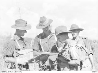 WEWAK POINT, NEW GUINEA, 1945-05-12. LIEUTENANT-COLONEL G.S. COX, COMMANDING OFFICER 2/4 INFANTRY BATTALION (2), CHECKING OVER A MAP WITH HIS OFFICERS. IN THE BACKGROUND STANDS LIEUTENANT-COLONEL ..
