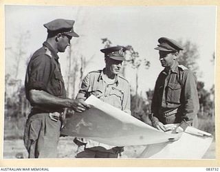 AITAPE, NEW GUINEA. 1944-11-23. LIEUTENANT- GENERAL STURDEE, COMMANDER FIRST ARMY, (2), STUDYING A MAP OF THE DRINIUMOR RIVER AREA DURING A TOUR OF AREAS CONTROLLED BY HQ 6 DIVISION