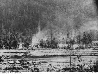 1943-03-03. PAPUA. JAPANESE UNSUCCESSFULLY ATTACK WAU ALLIED 25 POUNDERS BURST ON JAPANESE POSITIONS A SHORT DISTANCE FROM THE AERODROME AT WAU