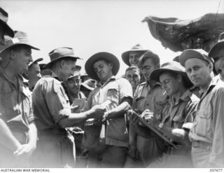 SOPUTA, NEW GUINEA. 1943-10-09. BOOKMAKER, H. W. REED GETS A SHOCK AS NX84253 PRIVATE WATTS OF HEADQUARTERS, 11TH AUSTRALIAN DIVISION PRESENTS A SHEAF OF SIX WINNING TICKETS ON "PADRE BILL", THE ..