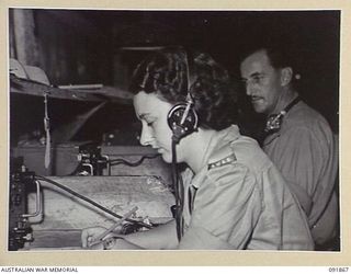 LAE, NEW GUINEA, 1945-05-16. SIGNALWOMAN J.I. SEE, WIRELESS OPERATOR (1), WORKING IN THE WIRELESS ROOM, SIGNALS HEADQUARTERS FIRSTY ARMY. AUSTRALIAN WOMEN'S ARMY SERVICE PERSONNEL ARE TAKING OVER ..