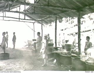 THE SOLOMON ISLANDS, 1945-10-13. JAPANESE NAVAL PERSONNEL STANDING BY IN A SECTION OF THEIR INTERNMENT CAMP. (RNZAF OFFICIAL PHOTOGRAPH.)