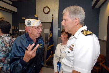 U.S. Navy USS OKLAHOMA Survivor, Paul Goodyear talks with CAPT. Frank J. Camelio (right), Commander of Pearl Harbor Naval Shipyard and Intermediate Maintenance Facility, on Dec. 6, 2006, after the Pearl Harbor Naval Shipyard's USS OKLAHOMA Lobby Display Dedication ceremony. The renovation and dedication honors the historic tie between the Pearl Harbor Shipyard workers who aided in the rescue of 32 Sailors from the capsized ship in the days following Dec. 7, 1941. (U.S. Navy PHOTO by Mass Communication SPECIALIST 1ST Class James E. Foehl) (Released)