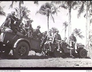 BUNA, PAPUA, 1945-01-08. MEN AND SUPPLIES GOING TO THE FRONT LINE AT BUNA. THE TRAILER IS HAULED BY A JEEP. (PHOTOGRAPHER: G. SILK)