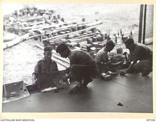 WEWAK POINT, NEW GUINEA. 1945-09-28. MEMBERS OF 1 FIELD SQUADRON, ROYAL AUSTRALIAN ENGINEERS, AT HEADQUARTERS 6 DIVISION CONSTRUCTING THE REFLECTING LIGHTS ON STAGE FOR THE CONCERT BY THE DARYA ..