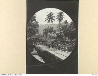 MILNE BAY, PAPUA, 1944-03-04. TROOPS VIEWED THROUGH THE PORT HOLE OF A TROOPSHIP AS THEY EMBARK FROM MILNE BAY FROM HOME LEAVE TO AUSTRALIA