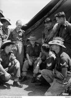 WEWAK POINT, NEW GUINEA. 1945-08-29. CHAPLAIN C.H. MCDONALD, 2/8 INFANTRY BATTALION, CHATTING WITH MEMBERS OF THE BATTALION ABOUT THEIR POST WAR JOBS