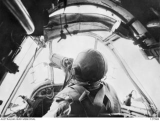 BISMARCK SEA. 1943-03-03. 260353 FLIGHT LIEUTENANT R. F. (TORCHY) UREN, NO. 30 SQUADRON RAAF, IN THE COCKPIT OF HIS BEAUFIGHTER AIRCRAFT TAKES A DRINK FROM A WATER BOTTLE AFTER LEAVING THE TARGET ..