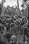 Mortuary ceremony, Omarakana: mourning women, faces blackened and heads shaved, carry banana leaf bundles for ritual exchange