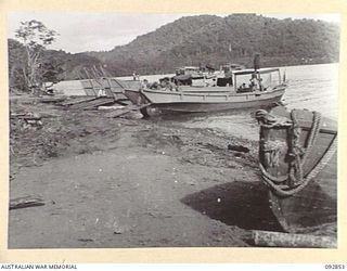 NANTAMBU, NEW BRITAIN, 1945-06. THE BEACHHEAD AT NANTAMBU, OPEN BAY. IN THE CENTRE IS A JAPANESE BARGE NOW USED BY THE COMMANDING OFFICER, 37/52 INFANTRY BATTALION AS A FAST RUN-ABOUT WHEN VISITING ..