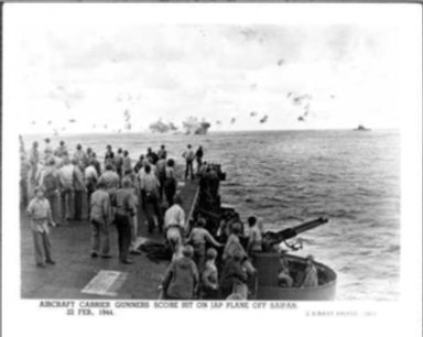 WORLD WAR II: AIRCRAFT CARRIER GUNNERS SCORE A HIT ON A JAPANESE PLANE OFF OF SAIPAN-SOLDIERS ON DECK WATCHING PLANE GO INTO THE WATER