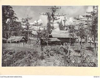 MOROKAIMORO, BOUGAINVILLE, 1945-06-06. HEADQUARTERS, 2/8 COMMANDO SQUADRON, VIEWED LOOKING DOWN "THE STRAND" TOWARDS "PICADILLY CIRCUS" AND THE COMMANDING OFFICER'S BATTLEROOM