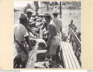 KAIRIRU ISLAND, NEW GUINEA, 1945-09-11. JAPANESE SOLDIERS UNLOADING THEIR PERSONAL BELONGINGS DURING THE TRANSFER OF AN ADVANCE PARTY OF 63 OFFICERS AND OTHER RANKS OF THE JAPANESE ARMY AND NAVY ..