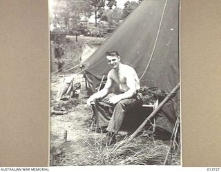 1942-12-02. NEW GUINEA. JAPANESE BOMB AN AMERICAN FIELD HOSPITAL. PTE. M.J. ALLEN, OF CYRACUSE NEW YORK, HAD A LUCKY ESCAPE WHEN A BOMB FELL ONLY A FEW FEET AWAY. (NEGATIVE BY G. SILK)