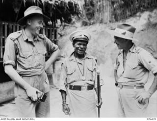 BASAMA-LAE AREA. NEW GUINEA. 1944-07-13. WARRANT OFFICER II, K WOODMAN, AUSTRALIAN NEW GUINEA ADMINISTRATIVE UNIT (1) KING BUMBU, CHIEF OF THE HUON GULF NATIVES (2) AND QX29649 LIEUTENANT R.L. ..