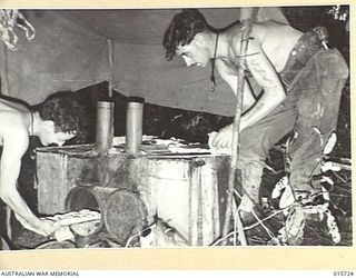 1943-09-15. NEW GUINEA. GOODVIEW JUNCTION COOKING SCONES WITHIN A HALF A MILE OF THE FRONT LINE AT GOODVIEW JUNCTION. ON THE LEFT IS CPL. JIM DRUMMOND, OF GUNBOWER, VIC. WITH HIM IS PTE. ALBERT ..