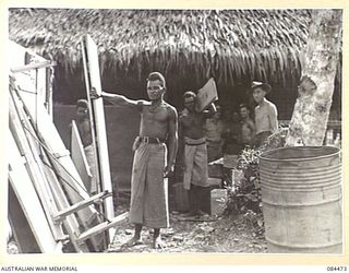 LAE, NEW GUINEA. 1944-12-22. NATIVES SUPPLIED BY ANGAU OUTSIDE THE YMCA CHAPEL. ON SUNDAY EVENINGS MEETINGS ARE HELD. THEY CONSIST OF COMMUNITY SINGING, TALKS BY A CHAPLAIN, OR WELFARE WORKER, ..