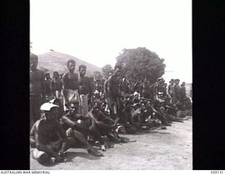 KILA, NEW GUINEA. 1943-10-24. A CROWD OF OVER 600 NATIVE LABOURERS LISTENING TO A SPEECH OF THANKS FOR THEIR WORK DELIVERED BY PP1 MAJOR GENERAL B. M. MORRIS DSO, GENERAL OFFICER COMMANDING ..