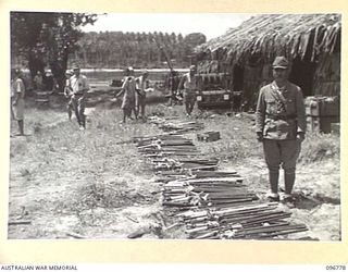 BUKA ISLAND, BOUGAINVILLE AREA, 1945-09-19. JAPANESE NAVAL TROOPS LISTING AND PLACING NAME TAGS ON THE SWORDS OF JAPANESE OFFICERS IN PREPARATION FOR THEIR COLLECTION BY AUSTRALIAN SURRENDER PARTY ..