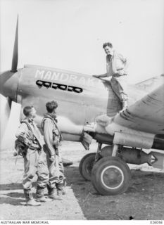 PAPUA, NEW GUINEA. 1942-07-27. THREE FIGHTER PILOTS OF THE ROYAL AUSTRALIAN AIR FORCE WHO HAVE SEEN ACTION OVERSEAS AND ARE NOW FIGHTING JAPANESE ZERO PLANES OVER NEW GUINEA MOUNTAINS. LEFT TO ..