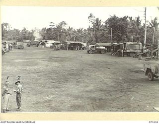 LAE, NEW GUINEA, 1944-03-24. VX43600 LIEUTENANT S. PENGELLY (1), WITH NX27041 WARRANT OFFICER CLASS 2 R. THOMPSON (2), IN THE AREA OF WORKSHOPS AND ADMINISTRATION BUILDINGS AT THE 2/125TH BRIGADE ..