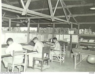 RAAF METEOROLOGICAL SECTION, MILNE BAY, 1945-05. LEFT TO RIGHT - FLIGHT SERGEANT METEOROLOGICAL ASSISTANT, FLYING OFFICER W. JORDAN (QUEENSLAND), FLYING OFFICER J.R. JOYCE, O.I. (NSW)