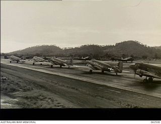 Port Moresby, New Guinea. 1944-01-06. Douglas C47 Dakota transport aircraft lined up on Wards Airfield, loaded with personnel of 57/60th Australian Infantry Battalion, warming up for the take off