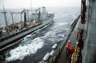 A pallet of supplies is passed on a wire highline rig between the fleet oiler USNS NEOSHO (T-AO 143) and the amphibious assault ship USS SAIPAN (LHA 2) as an underway replenishment is conducted off the coast of Liberia during Operation Sharp Edge. Marines embarked aboard the SAIPAN have been sent to the U.S. Embassy in Monrovia, Liberia, to augment security and evacuate U.S. and foreign nationals from the fighting between government and rebel forces