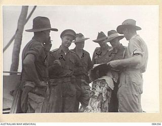 SUAIN PLANTATION, NEW GUINEA. 1944-12-08. BRIGADIER J.E.G. MARTIN, COMMANDER 19 INFANTRY BRIGADE, (5), AMONG SERVICE CHIEFS OF THE 19 INFANTRY BRIGADE CHECKING TERRAIN AND A PRELIMINARY SURVEY FOR ..