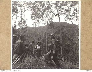 KOKODA TRAIL, NEW GUINEA. 1943-12-19. MR GEORGE HEATH (1) CHIEF CAMERAMAN OF CHAUVEL'S PRODUCTIONS, TAKING A CLOSE-UP OF QX3914 CORPORAL J. LORENZETTI (2) OF THE 2/9TH AUSTRALIAN INFANTRY BATTALION ..