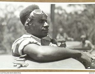 SOUTHPORT, QLD. 1944-01-18. A NEW GUINEA POLICE BOY SEATED IN THE TURRET OF A GENERAL GRANT M3 MEDIUM TANK OF THE 4TH ARMOURED BRIGADE