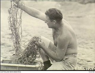 TOROKINA, BOUGAINVILLE ISLAND, SOLOMON ISLANDS. C. 1945-03-01. LEADING AIRCRAFTMAN T. W. FREEMAN, TOOWOOMBA, QLD, A MEMBER OF THE SPECIAL FISHING TEAM ORGANISED BY THE RAAF MEN TO KEEP THEM ..